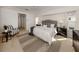 Neutral bedroom with carpeted floors features ceiling fan, windows, and a tufted headboard at 5071 Winter Rose Way, Venice, FL 34293