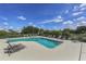 Sparkling community pool featuring plenty of lounge chairs for relaxing, surrounded by lush landscaping and a serene pond at 5071 Winter Rose Way, Venice, FL 34293