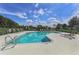 Inviting community pool with ladder access, surrounded by lounge chairs and lush landscaping under a clear blue sky at 5071 Winter Rose Way, Venice, FL 34293