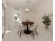 Bright dining area with tiled floors, neutral colors, modern chandelier and views of the backyard at 5071 Winter Rose Way, Venice, FL 34293