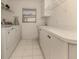 Functional laundry room with white cabinets, tiled floor, and efficient appliances at 5071 Winter Rose Way, Venice, FL 34293