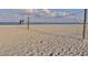 Scenic beach scene featuring a volleyball net, lifeguard station, and a calm ocean backdrop at 5071 Winter Rose Way, Venice, FL 34293