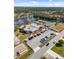 Scenic aerial view of a lakeside community featuring a pool, tennis courts, clubhouse, and parking area at 537 Foxwood Blvd, Englewood, FL 34223