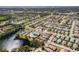 An aerial view of a residential area with a lake, showcasing single-story homes, and a community clubhouse with a pool at 537 Foxwood Blvd, Englewood, FL 34223