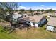 Aerial view of a backyard featuring a patio with outdoor seating and a spacious lawn surrounded by mature trees at 537 Foxwood Blvd, Englewood, FL 34223