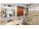 Well-lit bathroom with granite countertop, a glass shower, and dark wood vanity storage at 537 Foxwood Blvd, Englewood, FL 34223