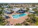 Aerial view of a community pool and gathering area with ample seating and a spa, all set in a lush, tropical landscape at 537 Foxwood Blvd, Englewood, FL 34223