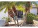 Front entrance surrounded by palm trees, rock landscaping, and a light blue accent piece at 537 Foxwood Blvd, Englewood, FL 34223