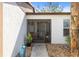 Front entrance with walkway, potted plants, decorative stone, and a screened storm door at 537 Foxwood Blvd, Englewood, FL 34223