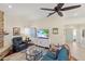 Bright living room with a blue sofa, stone fireplace, and a large TV for entertainment at 537 Foxwood Blvd, Englewood, FL 34223