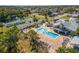 Aerial view of a community pool, tennis courts, and shuffleboard with lush green landscaping in a neighborhood at 537 Foxwood Blvd, Englewood, FL 34223