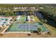 Aerial view of a community tennis court near a lake, complemented by shuffleboard courts, creating a vibrant recreation area at 537 Foxwood Blvd, Englewood, FL 34223