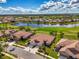 Aerial view of home with well-kept landscaping near a lake and golf course at 5371 White Ibis Dr, North Port, FL 34287