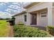 Home entrance with a decorative front door, manicured shrubs, and green grass at 5371 White Ibis Dr, North Port, FL 34287