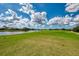 Beautiful golf course view with a serene pond and manicured green lawns under a partly cloudy sky at 5371 White Ibis Dr, North Port, FL 34287