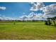 Scenic view of a lush green golf course under a beautiful blue sky with fluffy white clouds at 5371 White Ibis Dr, North Port, FL 34287