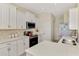 Kitchen featuring white cabinets, quartz countertop, and stainless steel appliances at 5371 White Ibis Dr, North Port, FL 34287