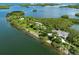 Stunning aerial view of a waterfront property with lush greenery, a house and a garden arbor at 564 Meadow Sweet Cir, Osprey, FL 34229