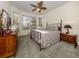 Bedroom boasts a ceiling fan, a large bay window for natural light, neutral walls and carpet, and decorative decor at 564 Meadow Sweet Cir, Osprey, FL 34229