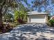 Beautiful home showcasing a well-maintained driveway, complemented by verdant landscaping and mature trees at 564 Meadow Sweet Cir, Osprey, FL 34229