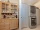 A well-designed laundry area boasts a stacked washer and dryer unit plus a decorative cabinet for linens and storage at 564 Meadow Sweet Cir, Osprey, FL 34229