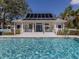 Poolside clubhouse with a solar panel roof and inviting porch seating area at 564 Meadow Sweet Cir, Osprey, FL 34229