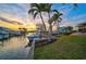 Beautiful backyard featuring a boat dock, lush lawn and sunset views at 641 Bayshore Rd, Nokomis, FL 34275