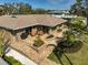 Aerial view of a home with a brick patio, outdoor grill, tiered landscaping, and a lush green lawn at 641 Bayshore Rd, Nokomis, FL 34275