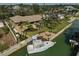 Aerial view of a home with dock, boat and landscaped yard, and outdoor seating and fire pit at 641 Bayshore Rd, Nokomis, FL 34275