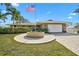 Charming single-story home with a circular brick paver driveway, lush lawn, and an American flag at 641 Bayshore Rd, Nokomis, FL 34275