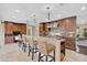 Spacious kitchen featuring a large island with seating, pendant lights, custom cabinets, and tile backsplash at 641 Bayshore Rd, Nokomis, FL 34275