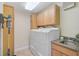 Bright laundry room with upper cabinets, granite counters, and modern appliances at 641 Bayshore Rd, Nokomis, FL 34275