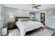 Stylish main bedroom with hard wood floors, ceiling fan, a large bed, walk-in closet and natural light at 641 Bayshore Rd, Nokomis, FL 34275