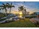 Scenic waterfront property featuring a private dock with a boat lift, lush landscaping, and stunning sunset views at 641 Bayshore Rd, Nokomis, FL 34275