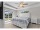 Spacious bedroom with water view, ceiling fan, and large sliding doors at 7057 Regina Dr, Englewood, FL 34224