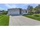 Single-story home with attached garage and landscaped yard at 7057 Regina Dr, Englewood, FL 34224