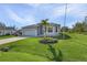 Single story house with gray siding, attached garage and palm tree at 7057 Regina Dr, Englewood, FL 34224