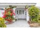 Front entrance with white door, red flowers, and a stone pathway at 721 Binnacle Point Dr, Longboat Key, FL 34228