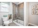 Modern bathroom featuring a glass-enclosed shower, neutral tile, and bright natural light at 10719 Ironwood Tree Way, San Antonio, FL 33576