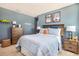 A beautifully decorated bedroom with light blue walls, two posters and a modern wooden headboard at 10719 Ironwood Tree Way, San Antonio, FL 33576