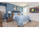 This bedroom is equipped with blue colored walls, window and a picture of a baseball glove at 10719 Ironwood Tree Way, San Antonio, FL 33576