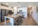 Bright kitchen featuring white cabinets, stainless steel appliances, a center island and tile flooring at 10719 Ironwood Tree Way, San Antonio, FL 33576