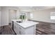 Open floor plan with kitchen island, hardwood floors, and sliding glass doors at 25503 Calusa Dr, Punta Gorda, FL 33955