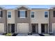 Tan three-story townhome with a two-car garage and landscaping at 530 Glenn Cross Dr, Ruskin, FL 33570