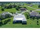 Wide aerial of modern home with a light colored metal roof amidst lush green surroundings and neighborhood streets at 17476 Vellum Cir, Punta Gorda, FL 33955