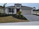 One-story home with gray siding, red door, and paver driveway at 9577 Vibrant Lane, Venice, FL 34292