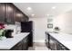 Modern kitchen with dark cabinetry, white countertops, and stainless steel appliances at 9715 Harrell Ave # 40, Treasure Island, FL 33706