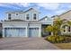 Two-story light blue house with a three-car garage and a landscaped front yard at 1005 Signet, Apollo Beach, FL 33572