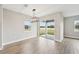 Dining room with wood-look floors, sliding glass doors, and a modern chandelier at 494 Sun Chaser Dr, Nokomis, FL 34275