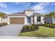 New home exterior with brown garage door and landscaped yard at 9576 Vibrant Lane, Venice, FL 34292